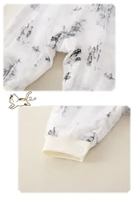 Detail of snap button closure and ribbed cuffs on baby romper with ink wash print