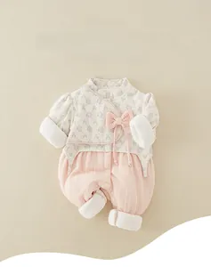 Detail of baby floral bodysuit featuring a pink bow and cozy ribbed knit texture