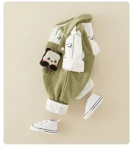 Detail of baby outfit featuring green textured overalls with a panda patch and bamboo shirt