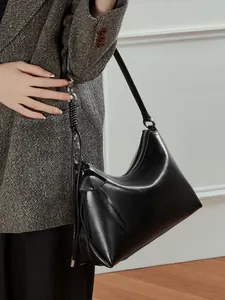 Bolso hobo minimalista de cuero negro con herrajes plateados y detalle de correa anudada