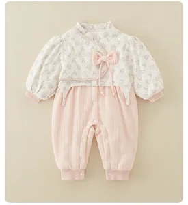 Detailed view of traditional Chinese style baby romper with bow and snap button closure