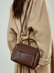 Sac à main minimaliste en cuir marron avec poignée dorée et bandoulière réglable chic