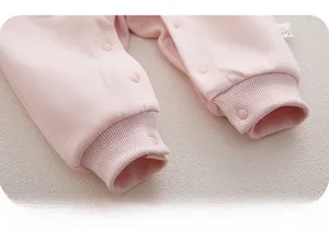 Détails macro d'un body rose pour bébé en coton de haute qualité avec boutons-pression