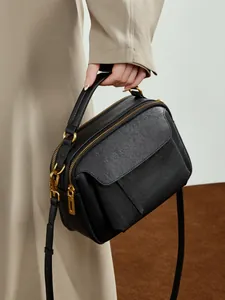 Sac à main minimaliste en cuir grainé noir avec détails dorés et double fermeture