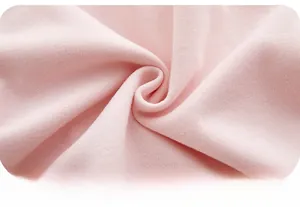 Gros plan sur la texture tricotée rose doux du vêtement en coton pour bébé fille