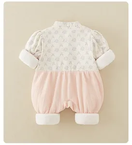 Detail of baby winter romper showing purple floral print and pink corduroy fabric texture