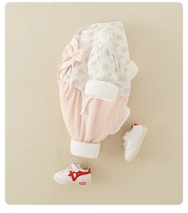 Detail of baby floral top with pearl bow and pink ribbed pants in a soft cotton set