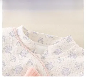 Detail view of cotton baby outfit showing floral print and waffle texture neckline