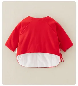 Détail du haut en coton rouge pour nouveau-né avec fermeture à nouer et doublure