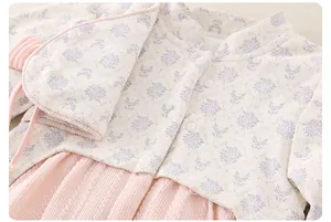 Detail of floral quilted fabric and pink cable knit texture on baby winter dress