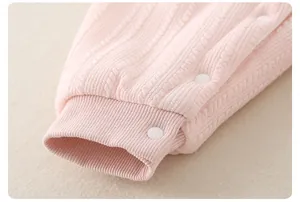 Close-up of pink baby romper showing soft knit texture and convenient white snap buttons