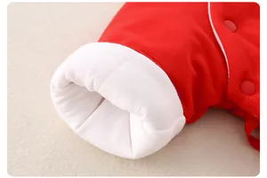 Détail d'un vêtement en coton rouge pour nouveau-né avec poignets blancs et boutons-pression