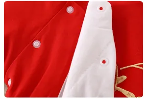 Détail de chemise en coton rouge pour nouveau-né avec broderie et boutons-pression