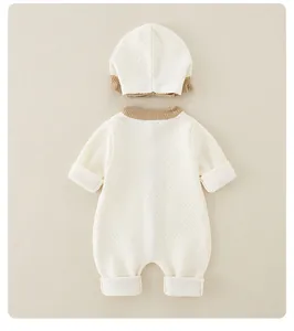 Dettaglio della tutina in maglia per neonati e cappello abbinato con trama a nido d'ape