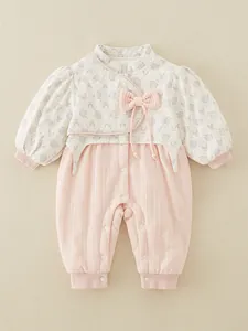 Floral quilted baby romper with warm pink velvet texture and pearl bow detail