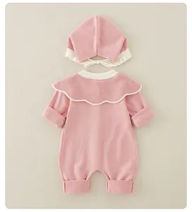 Detailaufnahme von rosa Baby-Strickstrampler mit weißem Spitzenkragen und passender Mütze