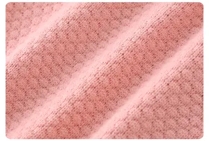 Dettaglio ravvicinato del tessuto a maglia rosa con trama delicata per neonati