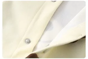 Macro detail of toddler outfit showing soft knit cotton fabric and durable metal snap buttons