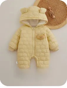 Detail of light yellow quilted baby jumpsuit with bear ears and small bear embroidery
