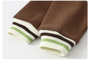Detailed view of elastic striped ribbed cuffs on a brown cotton knit children's jacket
