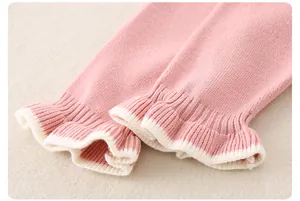 Detailansicht der rosa gestrickten Baby-Stramplerbündchen mit Rüschendesign