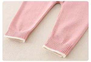 Detailaufnahme des rosa Strick-Baby-Stramplers mit Rippbündchen und beigem Kontraststreifen