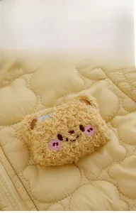 Close-up of baby romper featuring cloud quilting and a 3D plush bear head detail