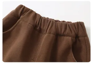 Detail showing elastic waistband and stitching on boys' brown cotton trousers