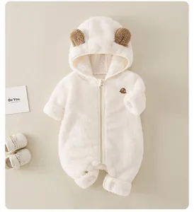 Posa piatta di una tutina neonato bianca con cappuccio a orecchie di orso in flanella