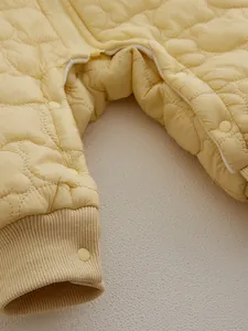 Insulated baby romper in pale yellow with bear quilted pattern and snap buttons