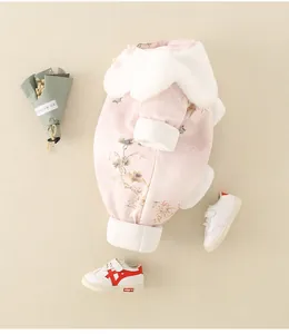 Detail eines dicken Baby-Stramplers mit Blumenmuster, Vogelstickerei und weißem Kunstpelz