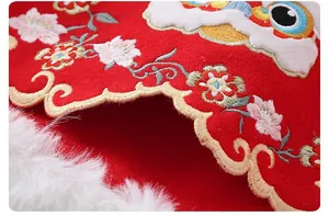 Detalle de la capa roja tradicional para niños con bordado de danza del león y ribete de pelo