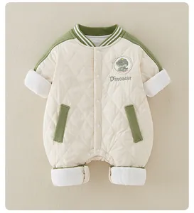Detail of baby quilted romper showing dinosaur embroidery and white snap buttons