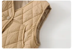 Dettaglio del gilet trapuntato kaki per bambini con cuciture a rombi e bottone in tessuto