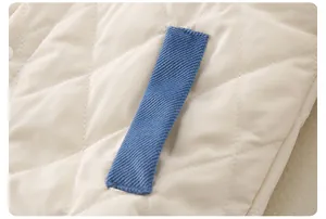Detail view of diamond quilted baby romper with blue corduroy stitching and soft fabric