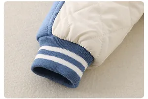 Detail of ribbed cuffs with blue and white stripes on a quilted baby romper sleeve