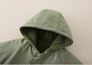 Dettaglio della tutina verde per neonati con spessa fodera in pile e bottone a pressione sul collo