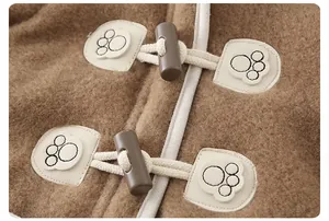 Detail of warm brown fleece baby coat with toggle closures and cute paw print patch