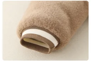 Close-up of baby winter jumpsuit featuring thick camel faux fur and striped ribbed cuffs