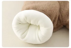 Close-up of thick white plush fleece lining and brown faux shearling cuff on baby jumpsuit