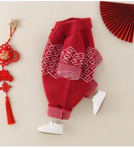 Detailed view of red baby romper with traditional Chinese knot patterns and white trim