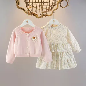 Dettaglio del cardigan rosa in maglia e della gonna a fiori per bambina
