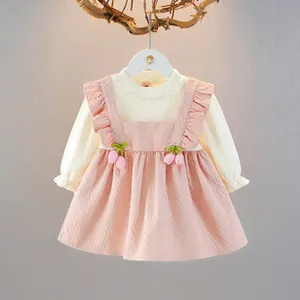 Dettaglio dell'abito rosa con decorazioni floreali a tulipano e camicia con volant