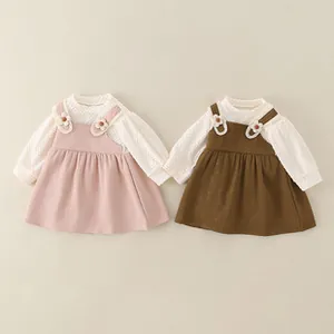Dettaglio del set bambina con maglia a nido d'ape e abito a bretelle con fiori applicati
