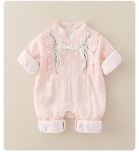Detail of floral embroidery and traditional knot buttons on pink infant romper