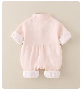 Detail of pink baby romper featuring floral jacquard fabric and white folded cuffs