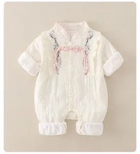 Detail of baby romper featuring Chinese plum blossom embroidery and pearl tassel buttons