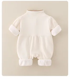 Détail d'une barboteuse bébé avec texture gaufrée et manches en tulle à pois blancs