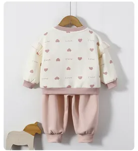 Detail of baby girl sweatshirt with ruffled shoulders, heart print and ribbed cuffs