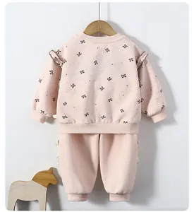 Detailed view of pink toddler girls bow print sweatshirt set with ruffle shoulder accents